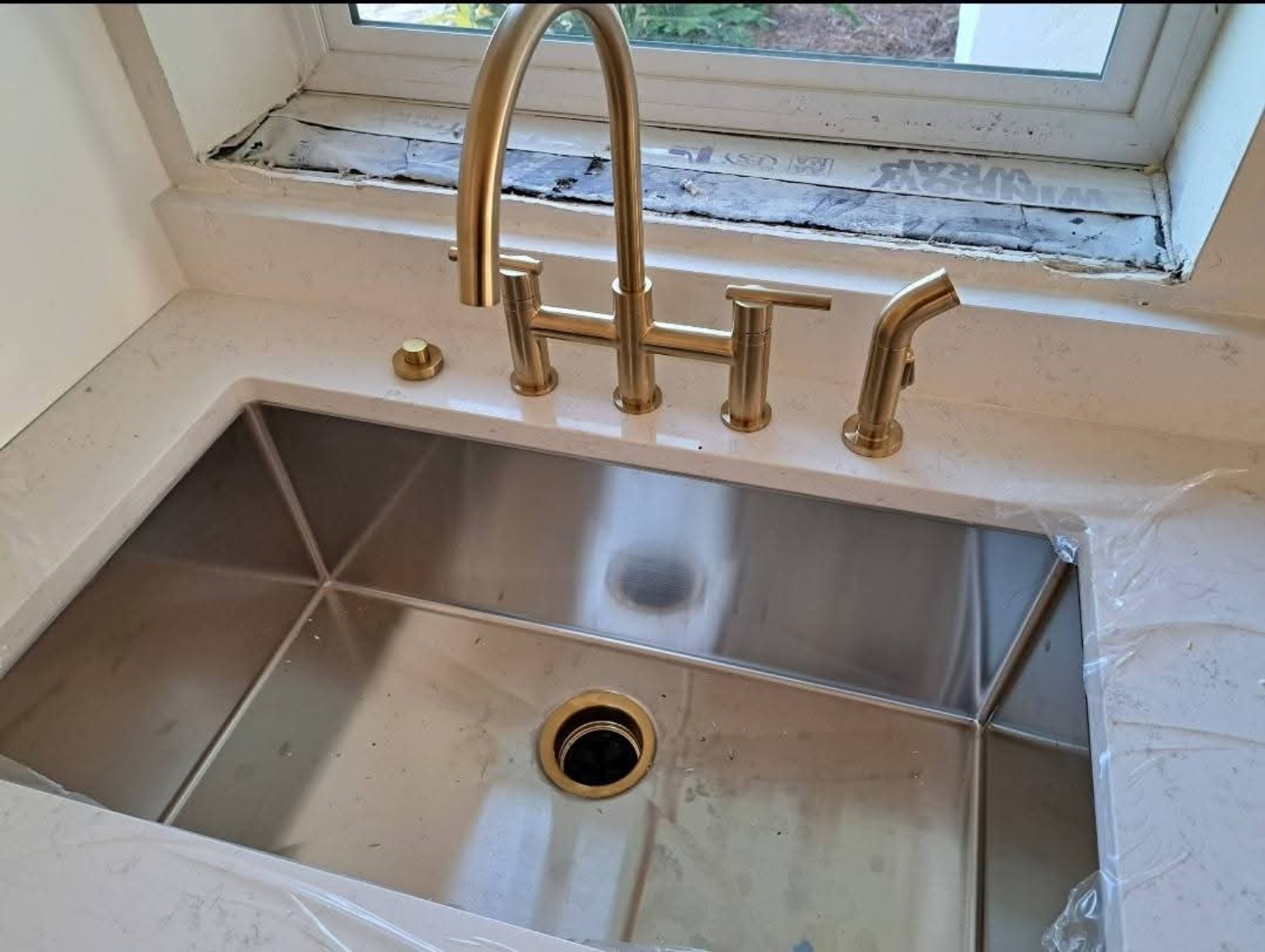 Stainless steel undermount sink with brushed gold kitchen faucet