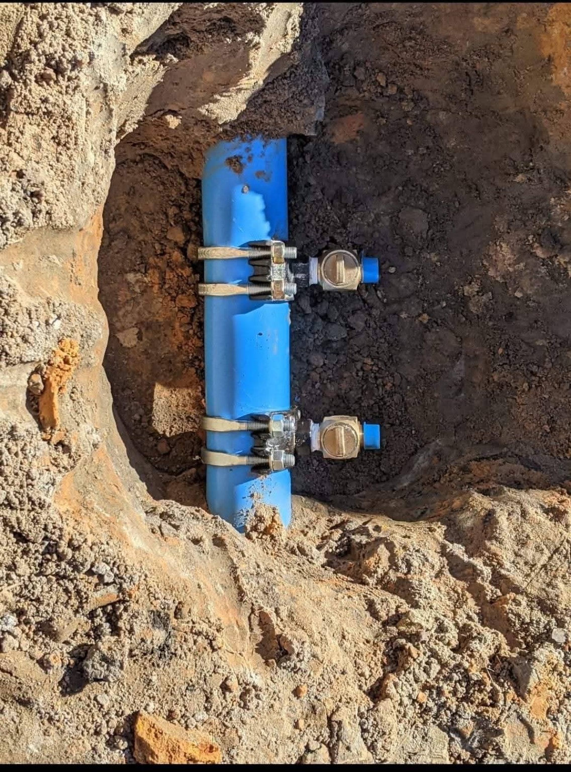 Two tapped service connections on underground blue water main